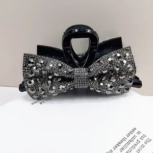 Close-up of black bow hair claw clip with sparkling grey rhinestones and crystals