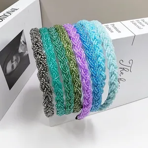 Detalle de siete diademas trenzadas de cuentas de colores sobre un libro decorativo