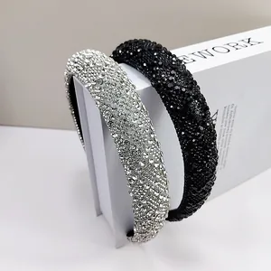 Detalle de diademas anchas acolchadas con pedrería de lujo en colores negro y plateado