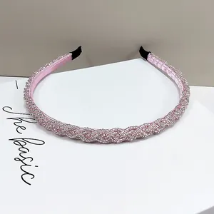 Detalle de diadema tejida con cuentas rosas con textura de cristal y forro de satén suave