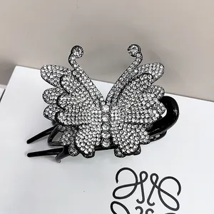 Macro di una clip a farfalla per capelli con strass scintillanti su sfondo grigio