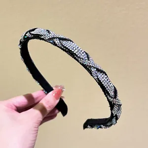 Close-up of a sparkling rhinestone headband with a luxury knotted woven fabric design