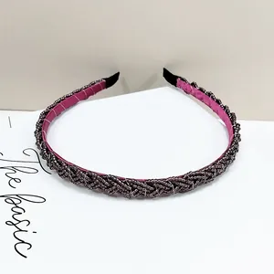 Detalle de diadema trenzada con cuentas de color púrpura y forro interior rosa