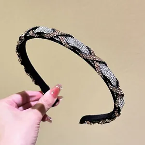 Detail of woven headband featuring dense champagne and silver rhinestones on black fabric