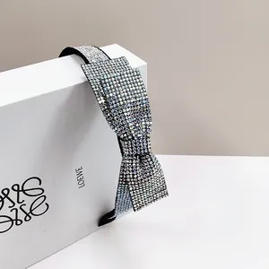 Elegant headband with colorful rhinestone bow on a minimalist white presentation box