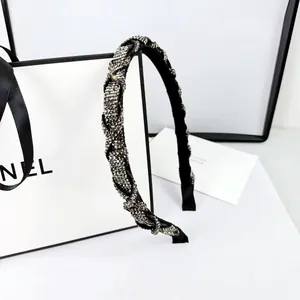 Detailed view of rhinestone headband with twisted braid design and ribbon tips