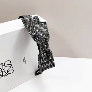 Close-up of sparkling black and grey rhinestone bow headband with elegant diamond finish