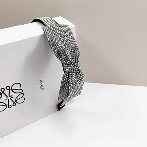 Detailed view of the sparkling rhinestone headband with a 3D bow on a jewelry display box