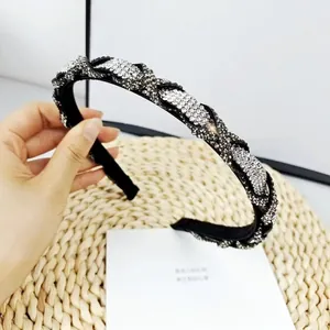 Detailed view of black woven headband featuring intricate sparkling rhinestone lattice pattern