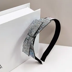 Detailed view of silver rhinestones on a large black bow headband with elegant sparkle
