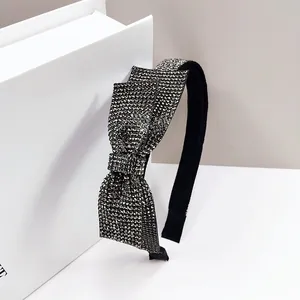 Detail showing the layered bow headband with shimmering silver rhinestones on black fabric