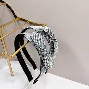 Close-up of sparkling rhinestone bow headband on a gold metal jewelry stand display