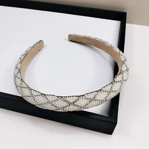 Détail macro de la texture matelassée avec perles et strass sur le serre-tête chic