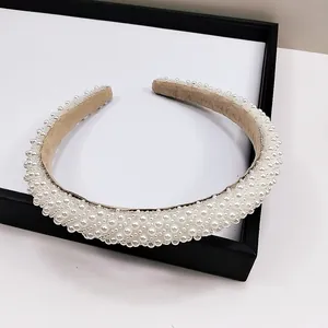 Détails des perles ivoires et strass sur un serre-tête fin en velours de style rétro