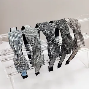 Elegant bow headbands with rhinestones in five colors on a clear display stand