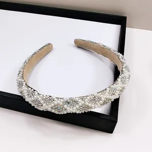 Détail de perles blanches et strass étincelants sur la doublure du serre-tête rembourré