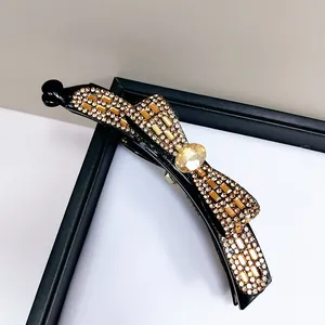 Makro-Detail der Bananen-Haarklammer mit champagnerfarbenen Kristallen und Strass