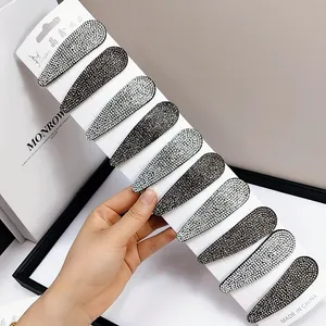 Dettaglio di un set di 10 fermagli per capelli BB con strass argento e grigi su carta