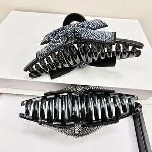 Détail de pinces à cheveux noires brillantes avec strass scintillants et un nœud