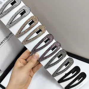 Dettaglio di fermagli per capelli a goccia con strass scintillanti in colori assortiti