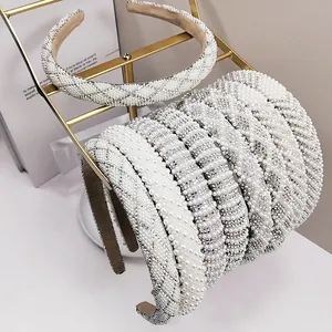 Détail de bandeaux élégants en perles blanches et strass sur un support doré