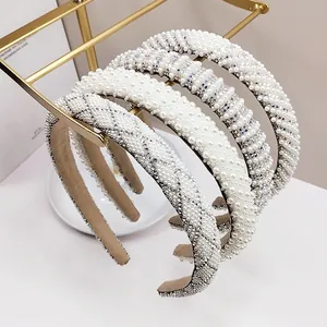 Détail macro de perles blanches et strass colorés sur des serre-têtes rembourrés