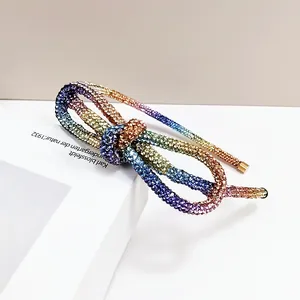 Close-up of rainbow gradient rhinestone headband with intricate bow design details