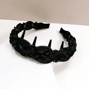 Detail of black rhinestone wave headband with woven satin fabric and inner comb teeth