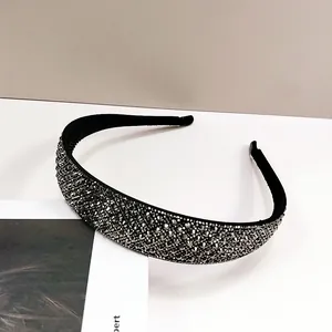 Detail eines dunkelgrauen Stirnbands mit Kristallsteinen und rutschfestem Innendesign