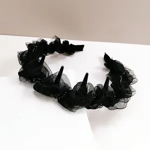Detail of gothic black lace headband with mesh ruffles and punk cone spikes decor