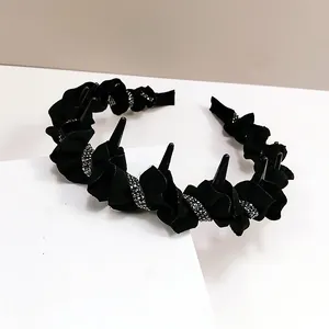 Close-up of black wavy headband with silver rhinestones and punk style texture details