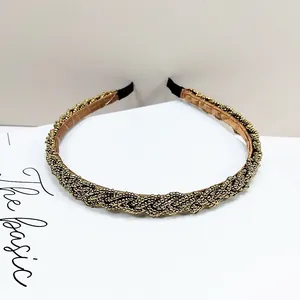 Detalle de diadema dorada con microcuentas tejidas a mano y forro interior de cuero suave
