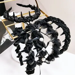 Detail of assorted black rhinestone headbands with pearls and lace on a gold stand
