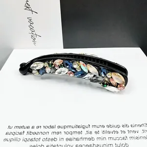 Minimalistische Haarklammer mit bunten Strasssteinen auf weißem Displaysockel