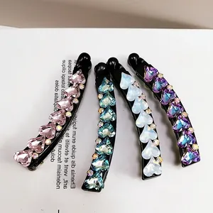 Set of four banana hair clips with heart-shaped crystals in pink, blue, white and purple