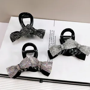 Detailed view of three bow-shaped hair claws with sparkling rhinestones in assorted colors