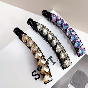 Three-piece heart-shaped K9 crystal banana hair clips in violet, champagne, and gold