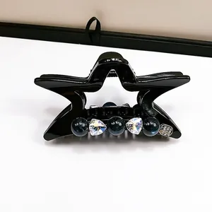 Dettaglio molletta per capelli a stella con perline blu, strass a cuore e medaglietta