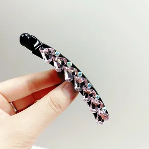 Detail of banana hair clip featuring pink heart crystals and sparkling aurora accents