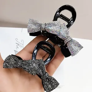 Detail view of bow hair clips with shimmering rhinestones in white and dark grey colors
