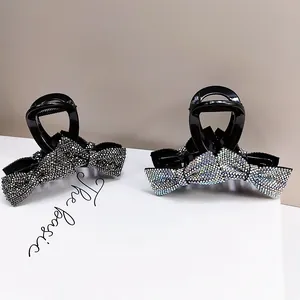 Detailed view of dual bow hair claws with sparkling rhinestones on white card