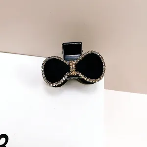 Detalle de pinza para el pelo con lazo de terciopelo negro y pedrería de cristal brillante