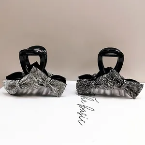Detailed view of two bow-shaped hair claws with sparkling rhinestones in silver and grey