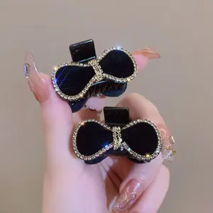 Detalle de elegantes pinzas para el pelo de terciopelo negro con borde de pedrería