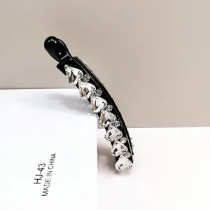 Macro shot of banana hair clip with sparkling heart-shaped K9 crystals and black base