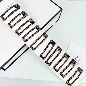 Macro view of 10-piece rectangular leopard print hair clips on a white display card