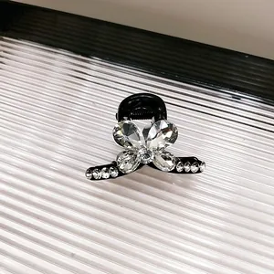 Détail d'une pince à cheveux papillon noire ornée de strass brillants et élégants