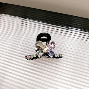 Détail d'une petite pince à cheveux papillon en cristal avec strass colorés sur résine