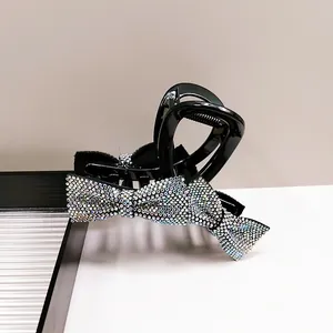 Detailed view of large shark clip with sparkling rhinestones on a black bow design