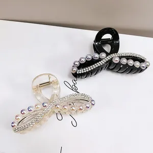 Dettaglio di fermacelli per capelli in acrilico nero e champagne con strass e perline